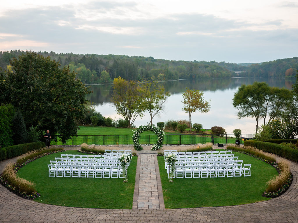lake front wedding ceremony with floral circle arch