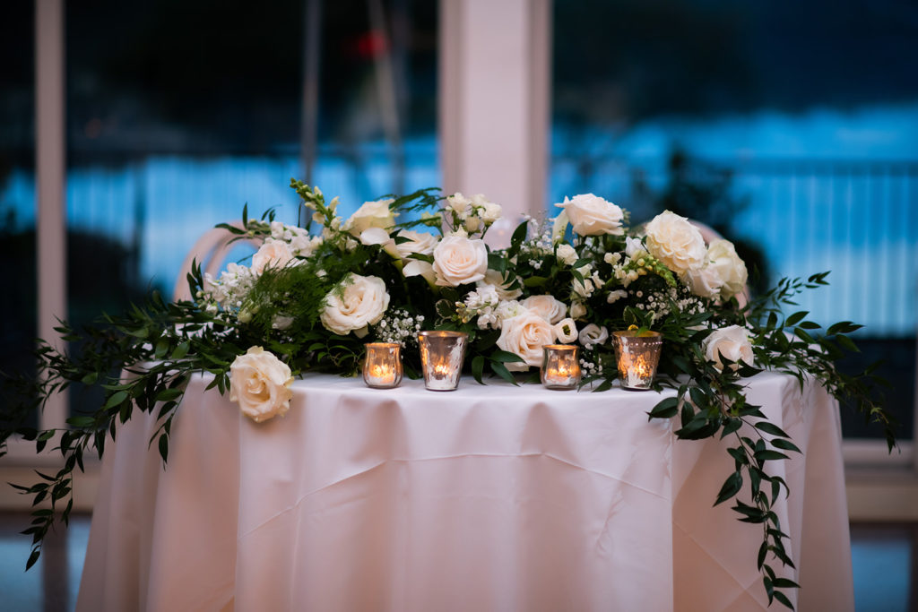 Sweetheart table white and green floral arrangement
