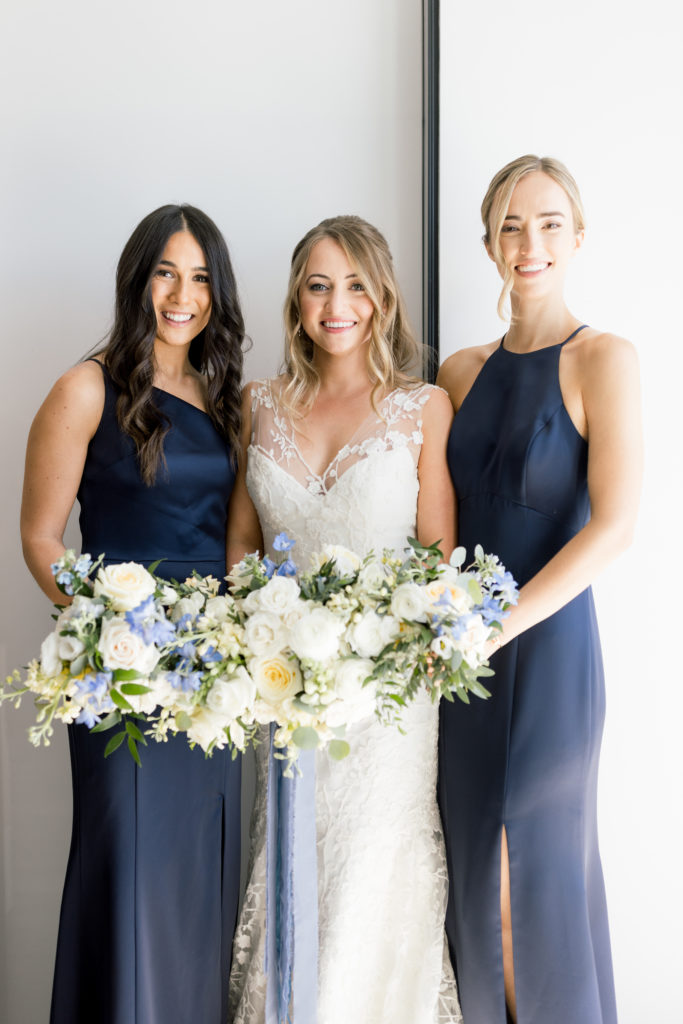 Elegant white and blue bride and bridesmaid bouquets with draping silk blue ribbon