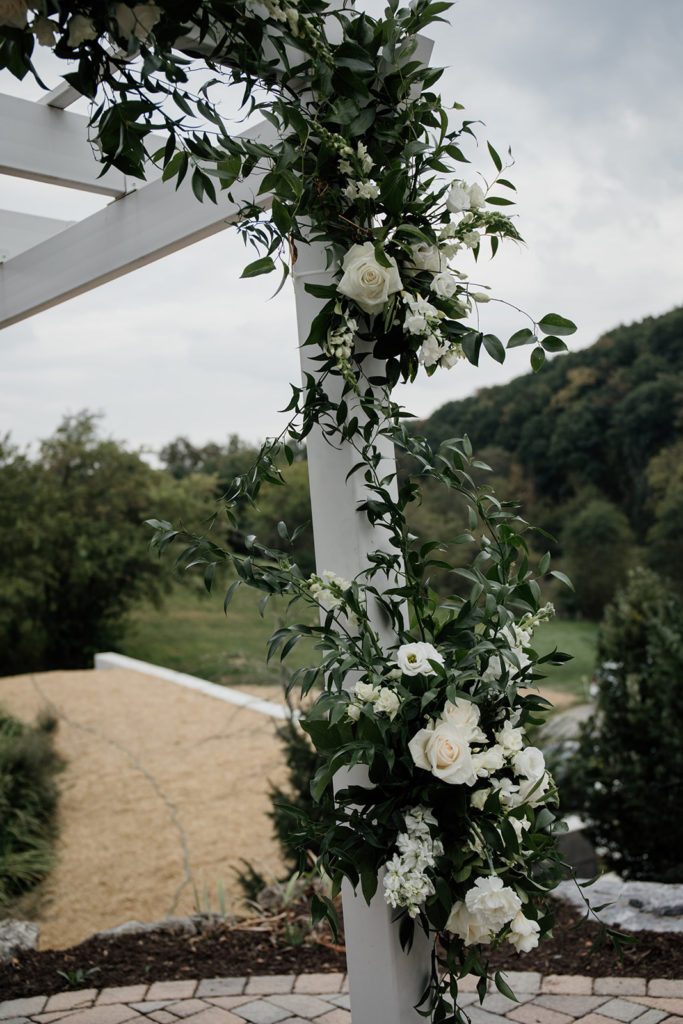 white and green floral wedding arch