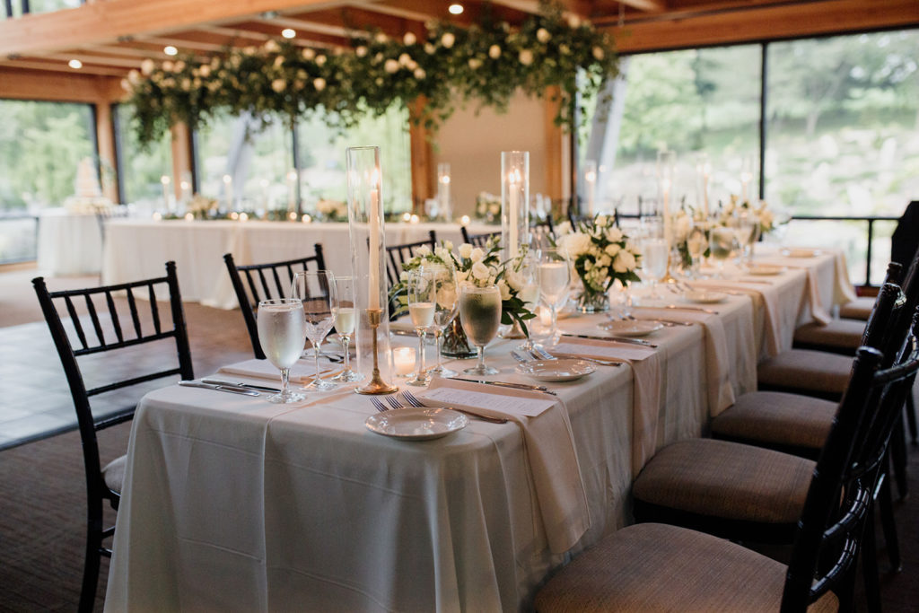 wedding reception tables with white florals and candles