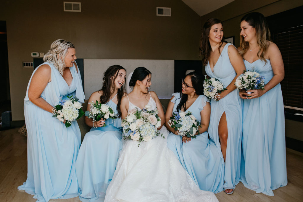 soft pastel bride and bridesmaids with floral bouquets and light blue dresses