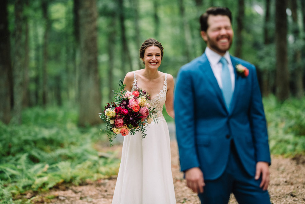 woodland wedding first look with bright colored florals 