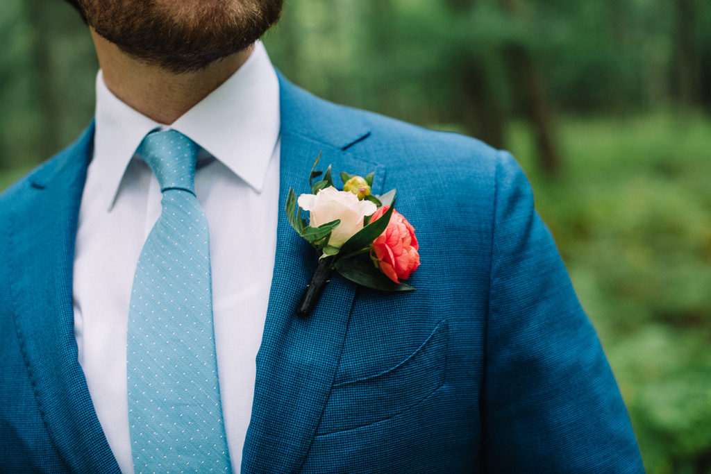 Bright floral boutonniere with salmon ranunculus